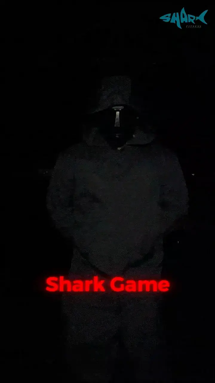A hooded figure standing in a dark gym, lit green
