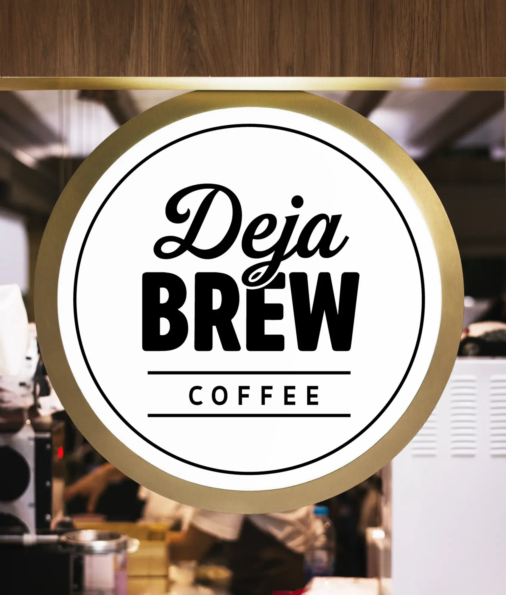 Mock-up: a round lit sign with the badge in a brass ring, hung over a café counter.