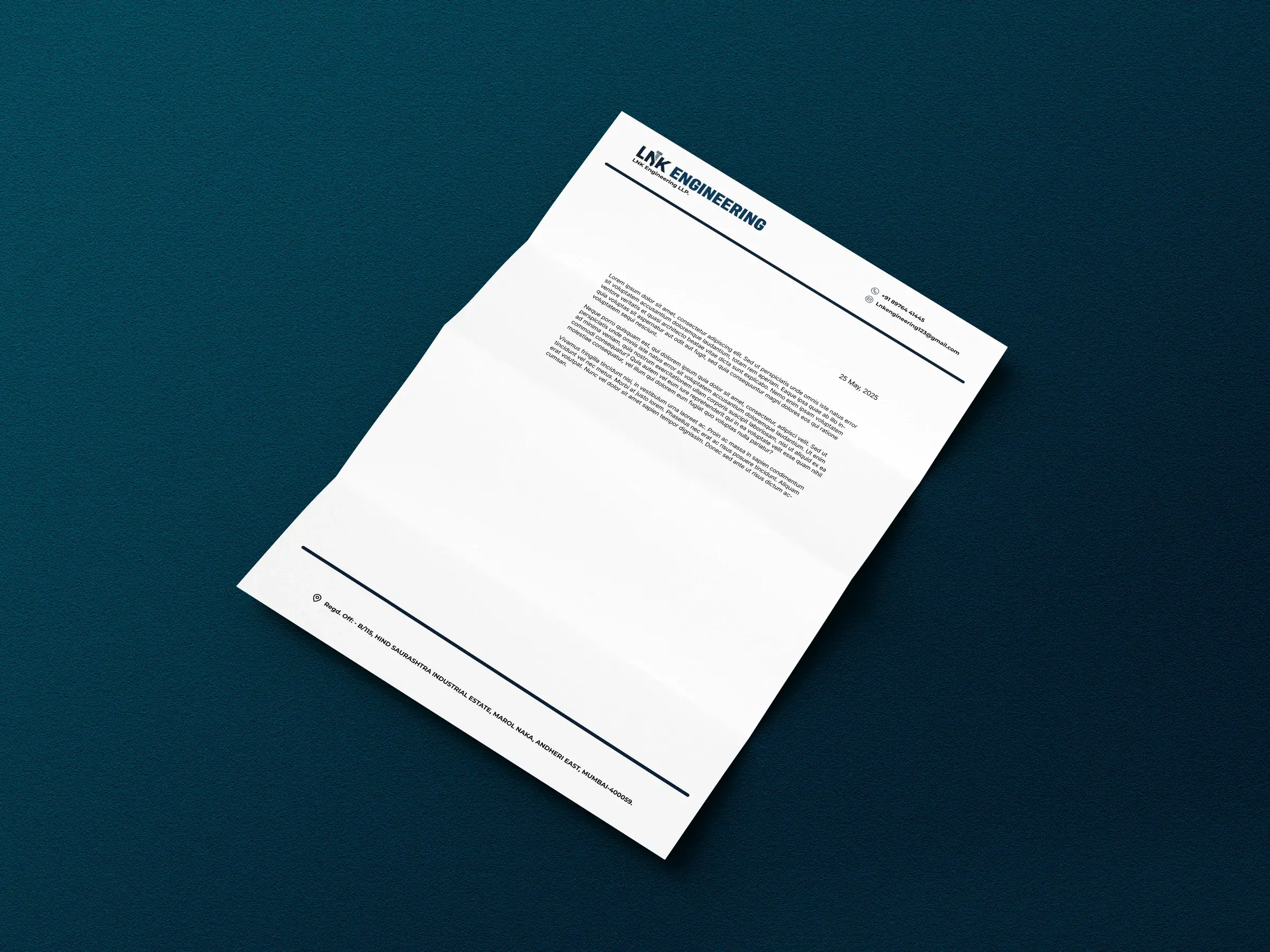 The LNK Engineering letterhead with a dated sample letter in placeholder text, folded in three and lying at an angle on dark blue card.