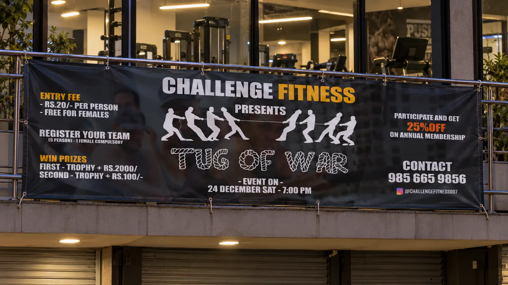 The Tug of War banner tied along the railing in front of the gym, early evening
