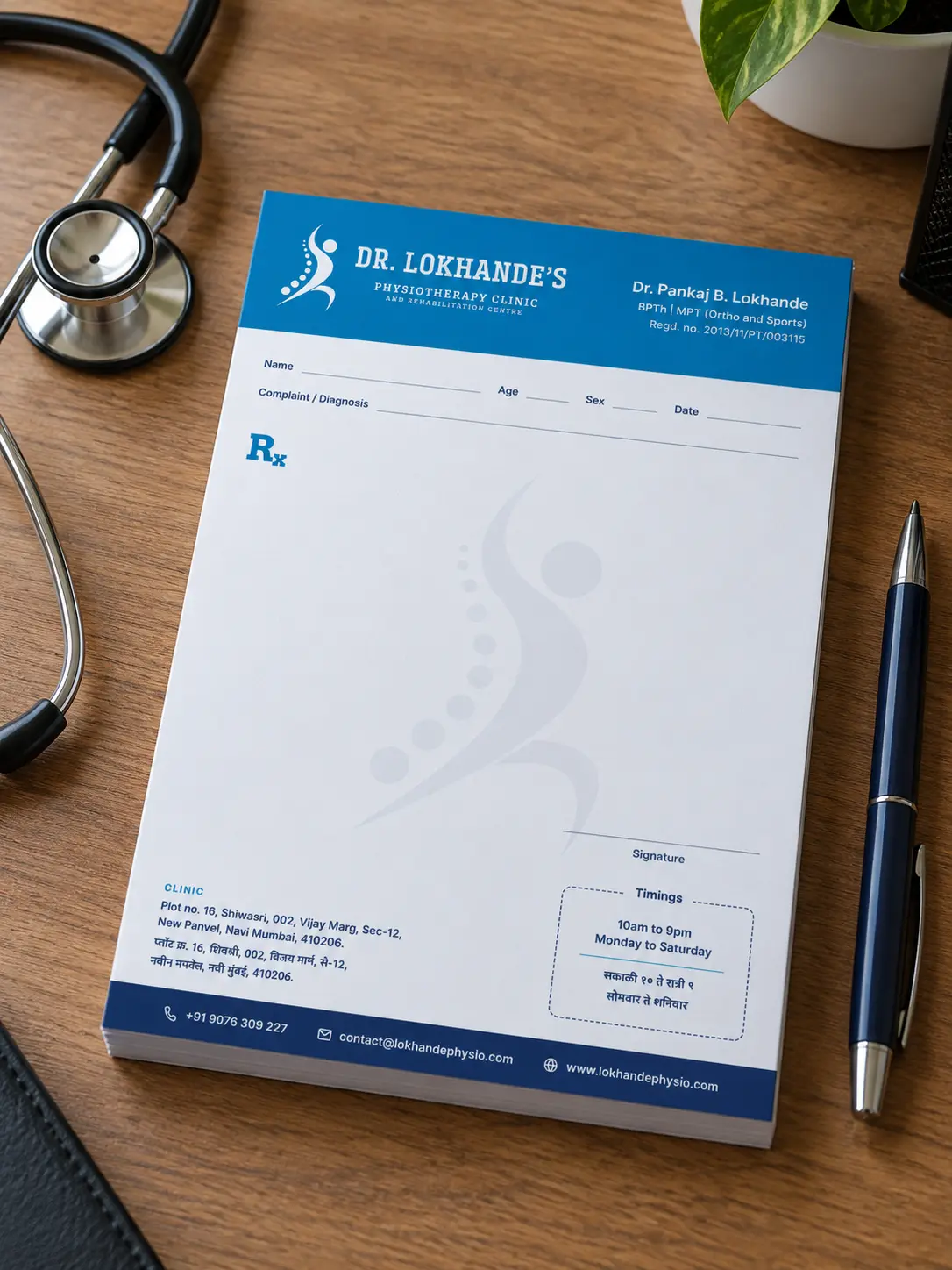 An A5 prescription pad with the clinic's blue header, beside a stethoscope and a pen on a wooden desk.